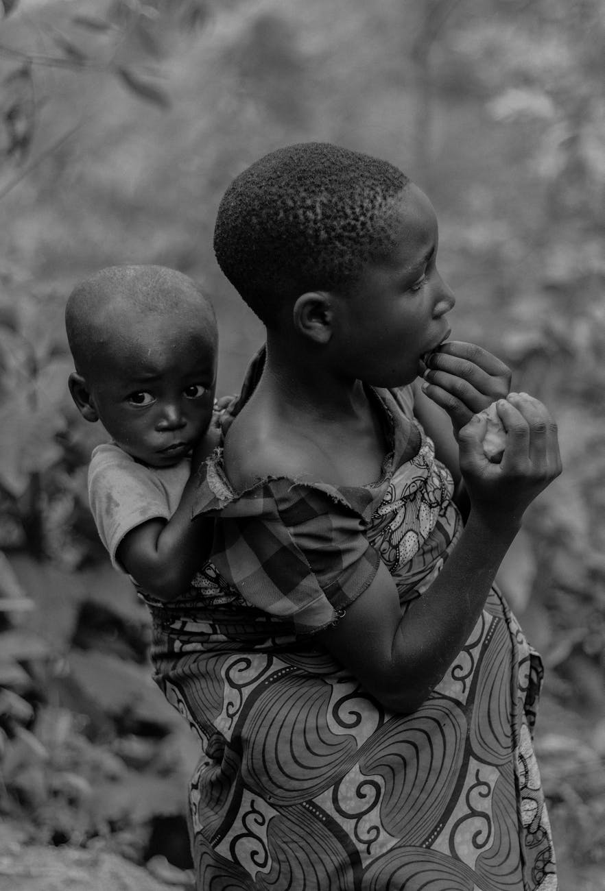 boy carrying brother in black and white
